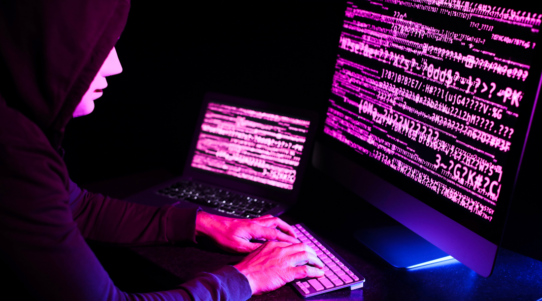 Hacker arbeitet im Dunkeln an Computern – Cyberangriff, Datendiebstahl und IT-Sicherheitsrisiken.