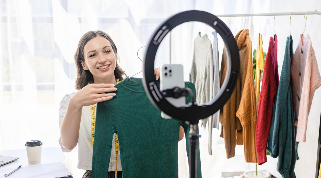 Influencerin präsentiert Kleidung vor Smartphone und Ringlicht – Mode, Livestream, Online-Shopping.