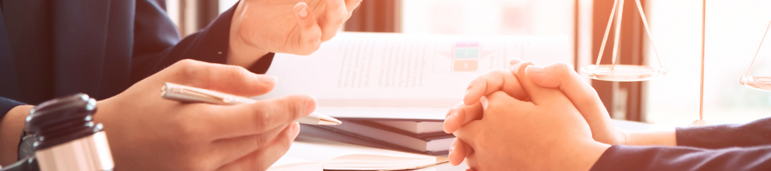 Anwalt und Mandant an einem Tisch in einer Besprächung.