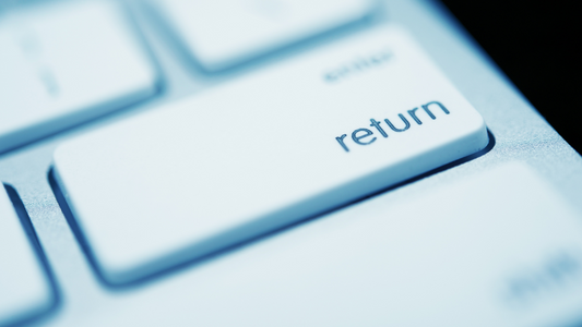 Ein Foto von einer rechten Ecke einer weißen Tastatur, wo auf der Taste Return steht. 