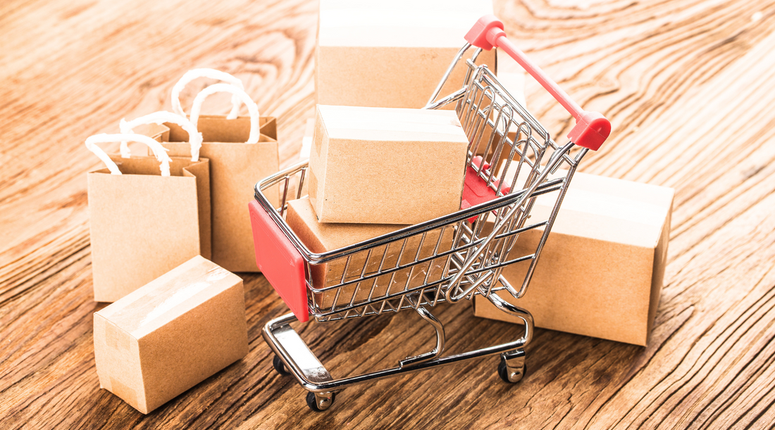 Einkaufswagen mit Paketen und Tüten symbolisiert Online-Shopping, E-Commerce und Versandhandel.