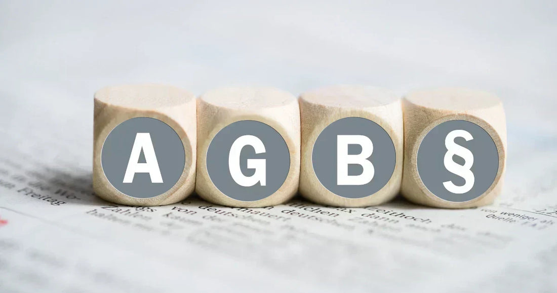 AGB Gesetzestexte rechtssicher im Online-Shop: Vier Holzsteine mit Paragrafen-Symbol auf einem Gesetzestext.