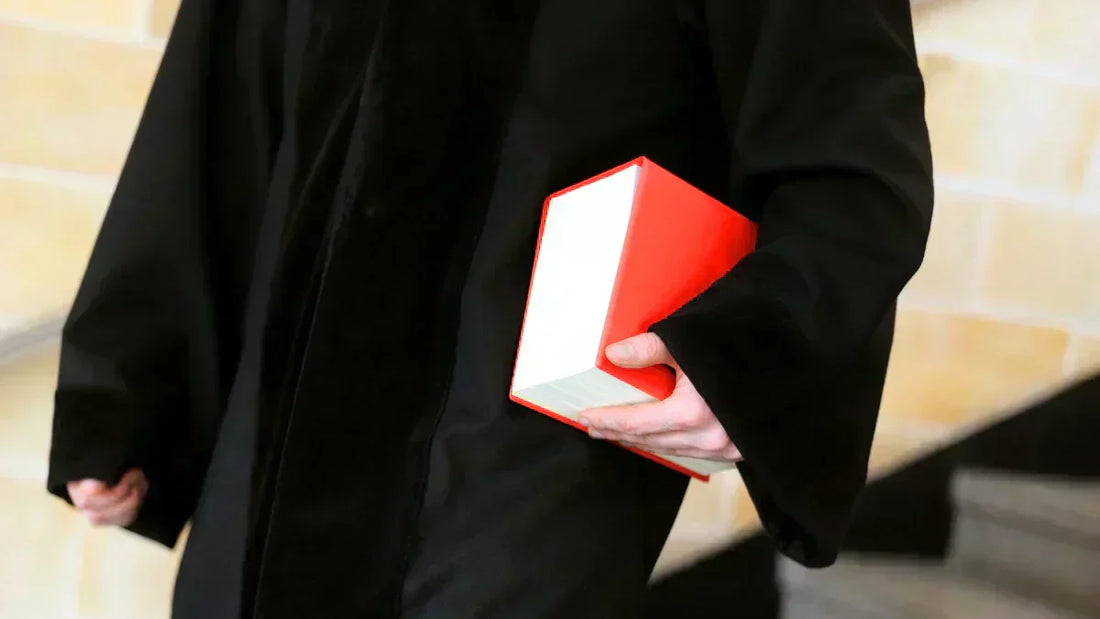 BGB Gesetzbuch für Händler – Jurist hält rotes Gesetzbuch für rechtssicheren E-Commerce.