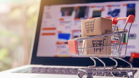 Cross-Selling im Warenkorb: Rechtssichere Optimierung mit Einkaufswagen und Paketen am Laptop.