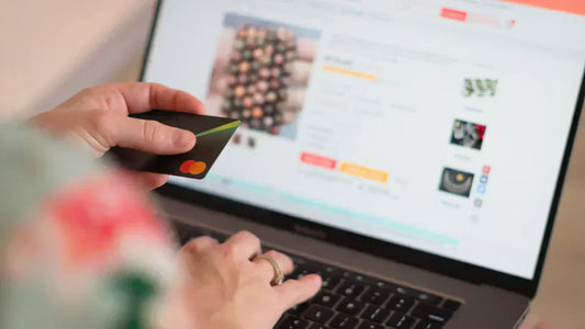 Ghost-Retouren-Falle: Person hält Kreditkarte vor Laptop zur Prüfung der Sicherheit beim Online-Kauf.