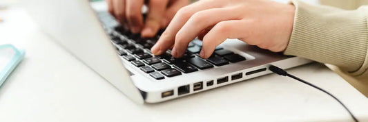 Hände tippen auf Laptop beim Onlinekauf digitaler Inhalte – Widerrufsrecht und EuGH Urteil zu Downloads im E-Commerce