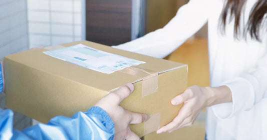 Wer haftet bei Nachbar-Zustellung: Bote übergibt Paket an Haustür zur Nachbarschaftsabgabe. 