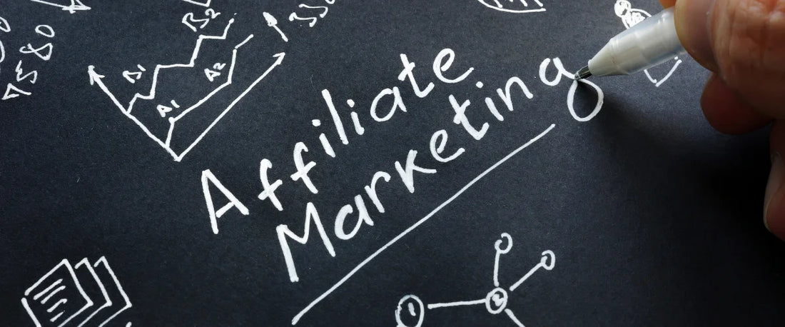 Hand schreibt Affiliate Marketing auf Tafel mit E-Commerce Diagrammen