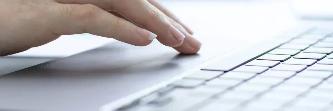 Hand auf Laptop-Tastatur prüft unautorisierte Lastschrift wegen Gastkonto-Betrug im Online-Shop.
