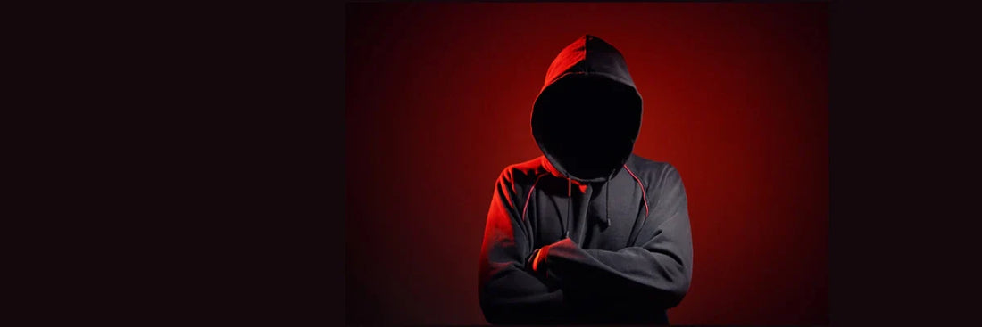 Hacker mit Hoodie im Dunkeln symbolisieren Identitätsdiebstahl, Cyberangriff, Phishing und Online-Betrugsgefahr.