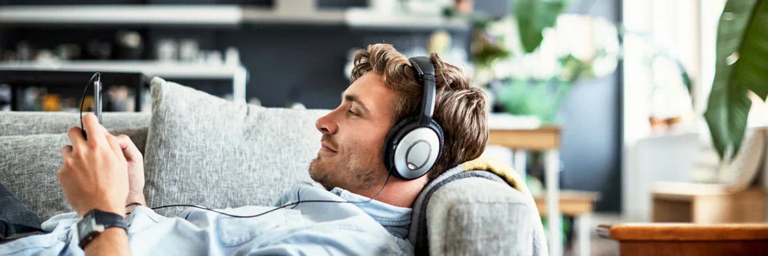 Musik-Streaming-App-Vergleich 2026: Ein Mann mit Kopfhörer nutzt Playlists am Smartphone