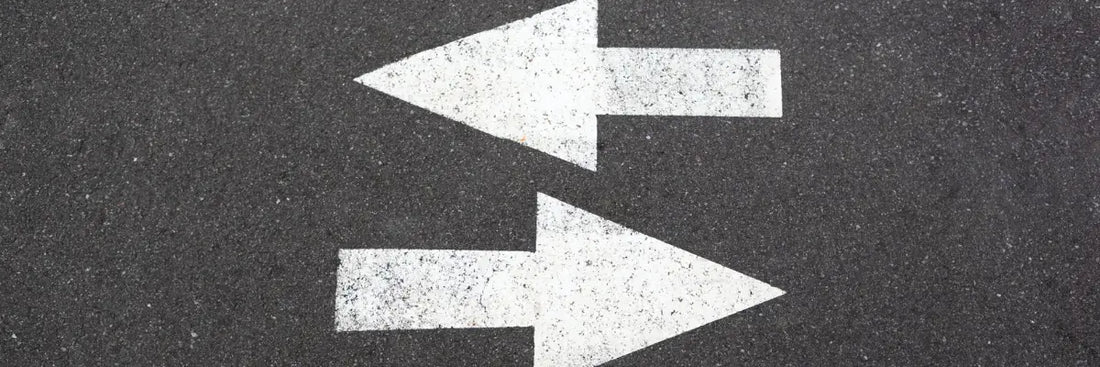 Zwei Pfeile auf Asphalt zeigen Richtungswechsel – Beweislastumkehr nach § 477 BGB bei Gewährleistung im Online-Handel