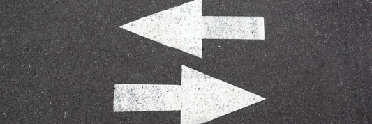 Zwei Pfeile auf Asphalt zeigen Richtungswechsel – Beweislastumkehr nach § 477 BGB bei Gewährleistung im Online-Handel