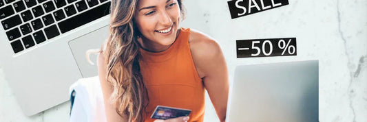 Frau vergleicht Preise online mit Laptop und Kreditkarte und nutzt 50 Prozent Rabatt Deals