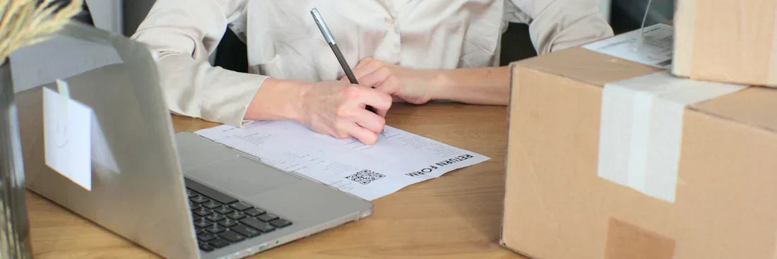Retourenformular neben Paket und Laptop für Garantie Reklamation im Onlinehandel