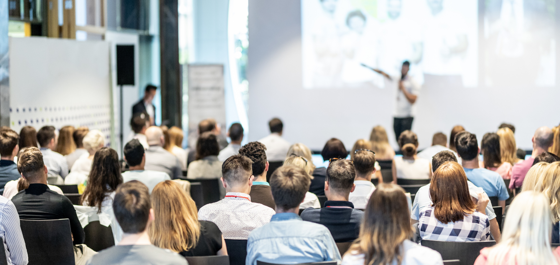 Menschen sitzen bei einer Shopper Safety Konferenz und hören einem Vortragenden zu – Business-Event über Online-Datenschutz, Abmahnungen und seine Folgen.